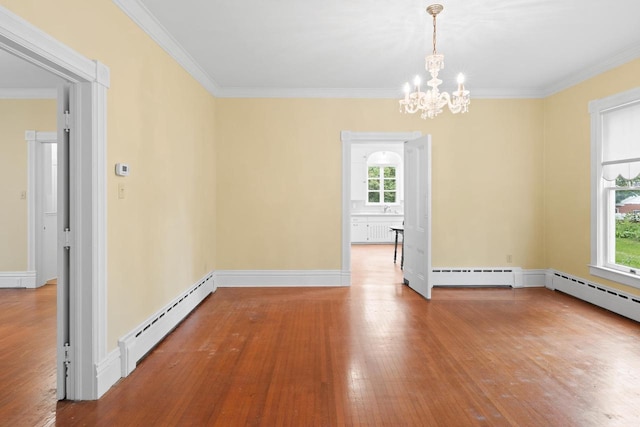 204 E Huron St, Berlin, WI 54923 - spare room featuring a baseboard radiator, plenty of natural light, hardwood / wood-style flooring, a chandelier, and ornamental molding
