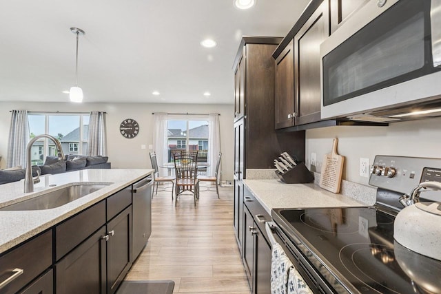6017 Lyda Woods Ln, Madison, WI 53718 - kitchen featuring appliances with stainless steel finishes, dark brown cabinets, light wood-type flooring, recessed lighting, and decorative light fixtures