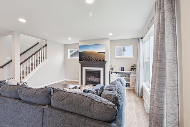 6017 Lyda Woods Ln, Madison, WI 53718 - living area with recessed lighting, light wood-type flooring, healthy amount of natural light, a glass covered fireplace, and stairway
