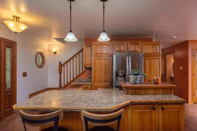 4114 Sheard Rd, Dover, WI 53139 - kitchen with stainless steel fridge with ice dispenser, brown cabinets, a kitchen bar, and a center island