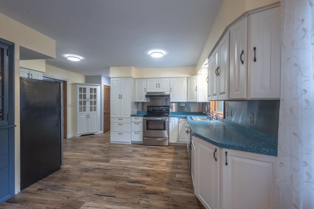1718 N 13th St, Wausau, WI 54403 - kitchen featuring stainless steel electric range, freestanding refrigerator, dark countertops, white cabinets, and under cabinet range hood