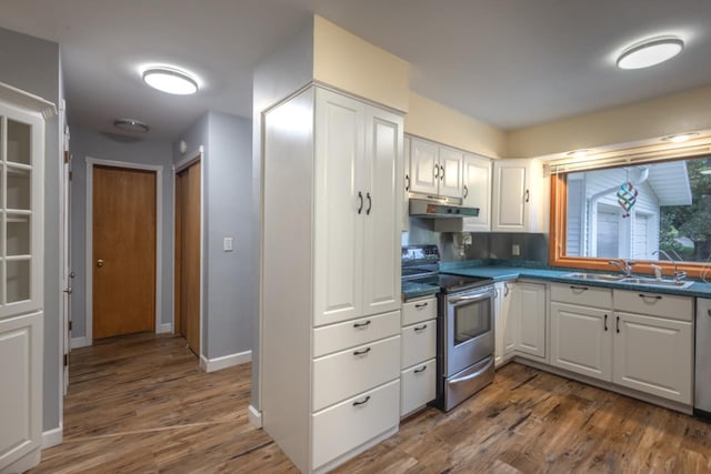 1718 N 13th St, Wausau, WI 54403 - kitchen featuring electric range, under cabinet range hood, dark wood-style floors, white cabinetry, and dark countertops