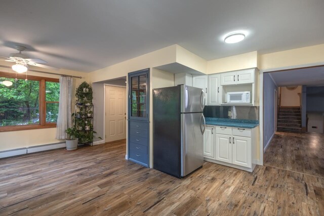 1718 N 13th St, Wausau, WI 54403 - kitchen with freestanding refrigerator, white microwave, white cabinetry, a ceiling fan, and wood finished floors