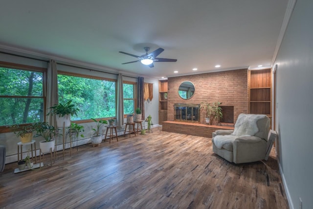 1718 N 13th St, Wausau, WI 54403 - living area featuring ornamental molding, wood finished floors, ceiling fan, a brick fireplace, and recessed lighting