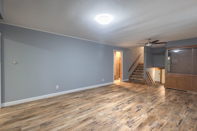 1718 N 13th St, Wausau, WI 54403 - unfurnished living room with stairway, wood finished floors, a ceiling fan, and crown molding