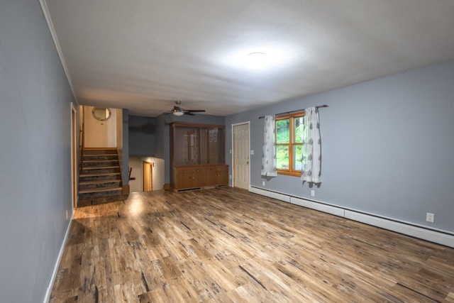 1718 N 13th St, Wausau, WI 54403 - unfurnished living room with a baseboard heating unit, wood finished floors, stairway, and ceiling fan