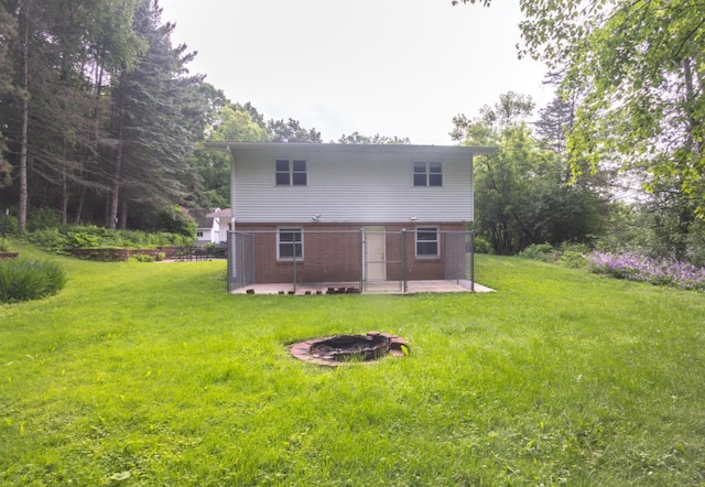 1718 N 13th St, Wausau, WI 54403 - back of property featuring a patio, a yard, an outdoor fire pit, and brick siding