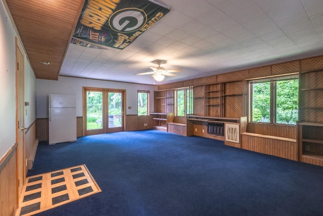 1718 N 13th St, Wausau, WI 54403 - unfurnished living room with wooden walls, carpet flooring, ceiling fan, and wainscoting