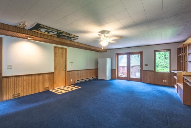 1718 N 13th St, Wausau, WI 54403 - empty room featuring wainscoting, wood walls, baseboard heating, carpet floors, and ceiling fan