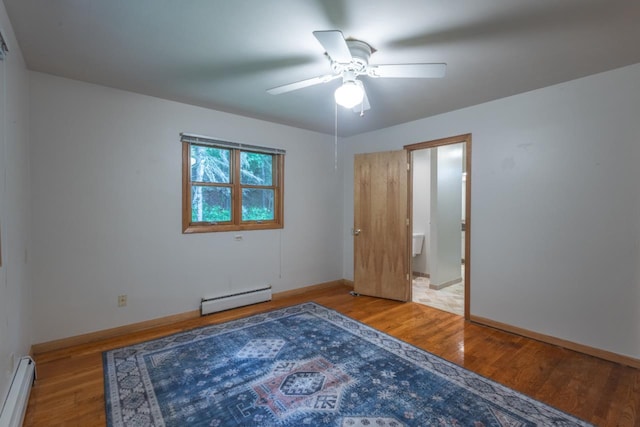 1718 N 13th St, Wausau, WI 54403 - unfurnished bedroom with baseboard heating, wood finished floors, and a ceiling fan