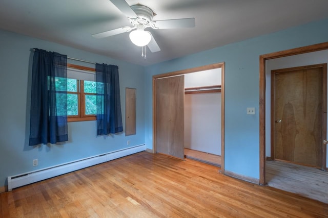1718 N 13th St, Wausau, WI 54403 - unfurnished bedroom with a baseboard radiator, light wood-style flooring, a closet, and a ceiling fan