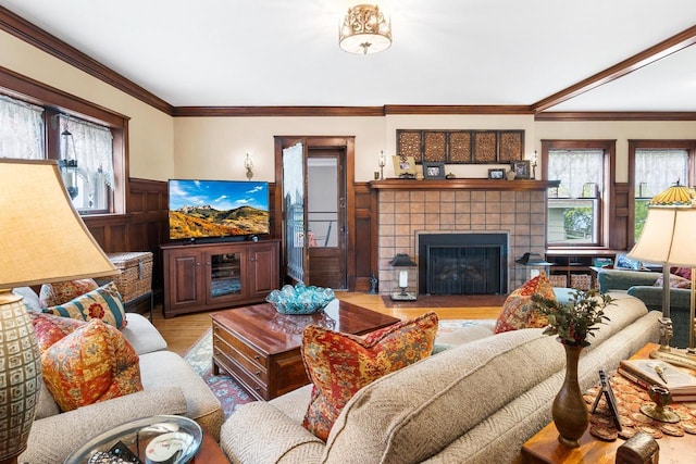 730 3rd St S, Wisconsin Rapids, WI 54494 - living area with plenty of natural light, wood finished floors, a tiled fireplace, wainscoting, and crown molding