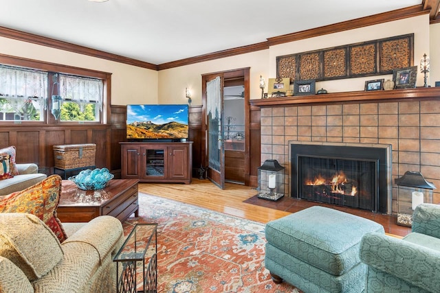 730 3rd St S, Wisconsin Rapids, WI 54494 - living area with wood finished floors, ornamental molding, a tile fireplace, and wainscoting