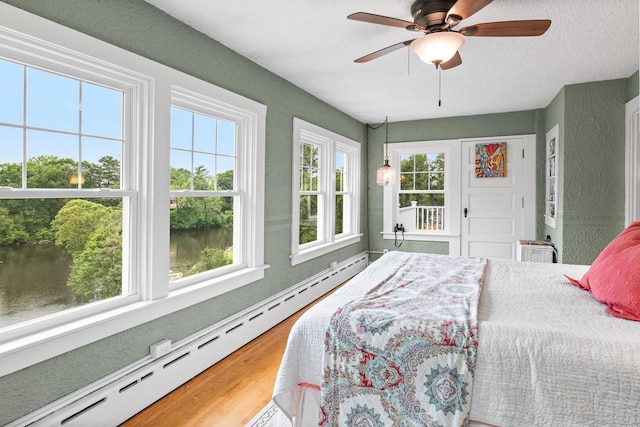 730 3rd St S, Wisconsin Rapids, WI 54494 - bedroom with a baseboard radiator, wood finished floors, a water view, and a ceiling fan