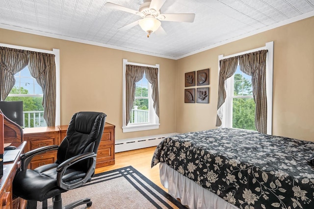 730 3rd St S, Wisconsin Rapids, WI 54494 - bedroom with multiple windows, wood finished floors, a baseboard heating unit, crown molding, and a desk
