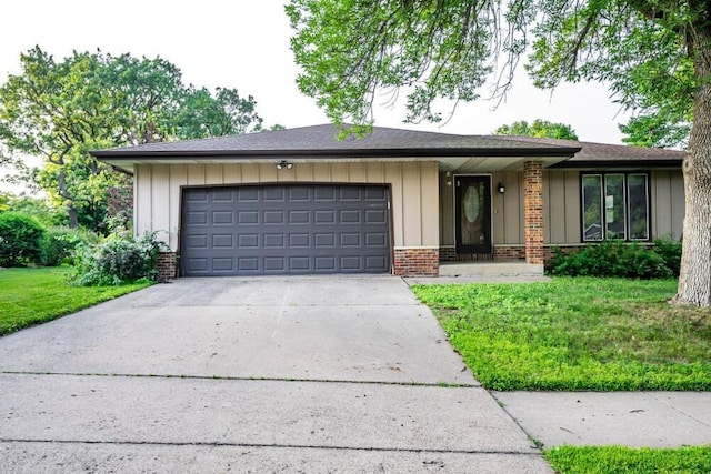 1311 Hickory St, Onalaska, WI 54650 - view of front facade with brick siding, an attached garage, driveway, a front lawn, and board and batten siding