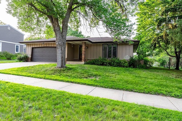 1311 Hickory St, Onalaska, WI 54650 - view of front of home with board and batten siding, an attached garage, driveway, and a front yard