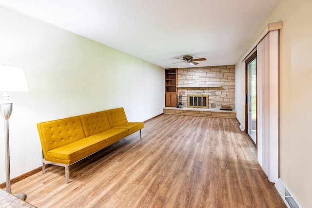 1311 Hickory St, Onalaska, WI 54650 - unfurnished room featuring ceiling fan, wood finished floors, a fireplace, and built in shelves