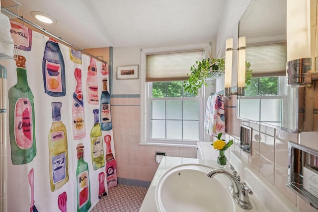 5961 N Lake Dr, Whitefish Bay, WI 53217 - full bathroom with plenty of natural light, tile walls, a shower with shower curtain, a wainscoted wall, and vanity