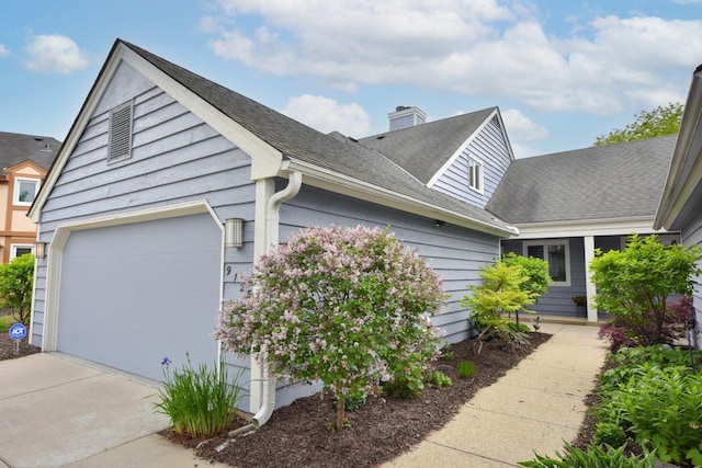 9125 N Briarwood Ct, Bayside, WI 53217 - view of side of property featuring driveway, a chimney, a shingled roof, and a garage
