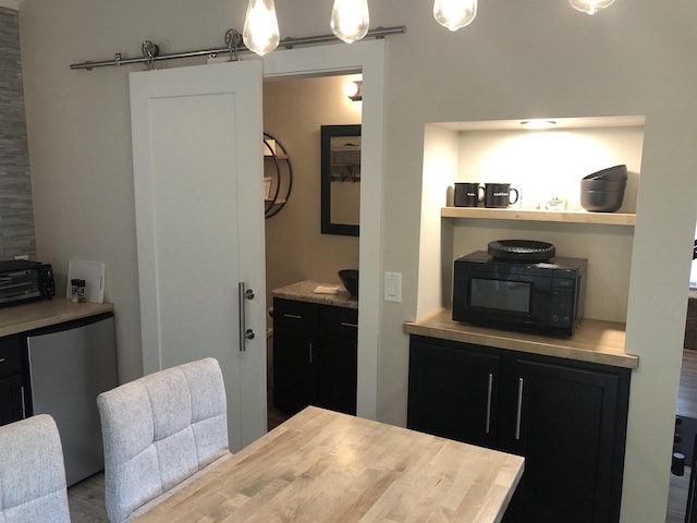 N4857 Oak Valley Ln, Elroy, WI 53929 - dining space with a barn door and wood finished floors
