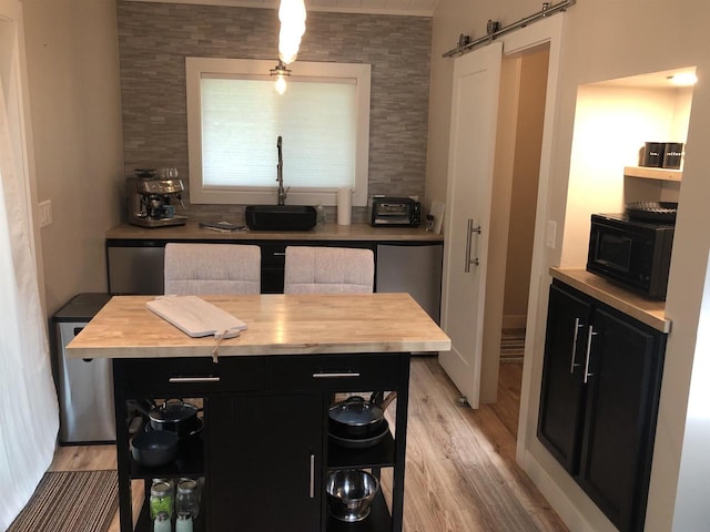N4857 Oak Valley Ln, Elroy, WI 53929 - kitchen featuring dark cabinetry, wooden counters, a barn door, light wood finished floors, and black microwave