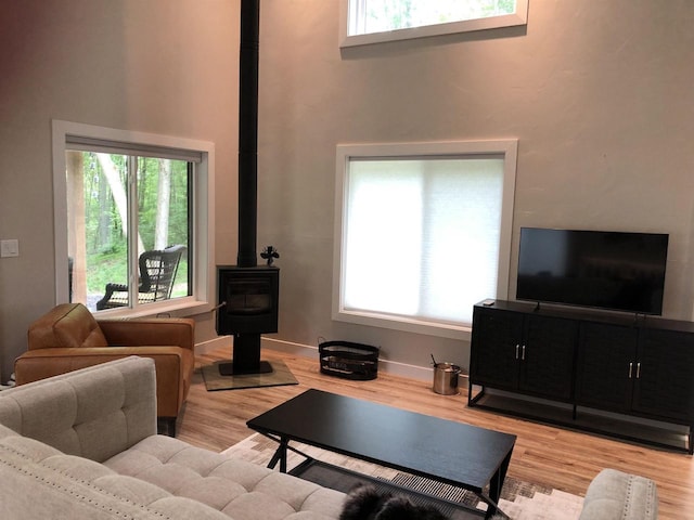 N4857 Oak Valley Ln, Elroy, WI 53929 - living area with a wood stove, plenty of natural light, wood finished floors, and a high ceiling