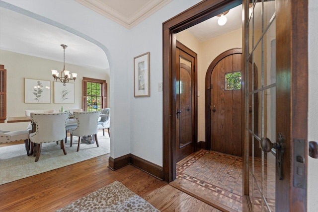 4765 N Woodburn St, Whitefish Bay, WI 53211 - entrance foyer with arched walkways, a chandelier, wood finished floors, and ornamental molding