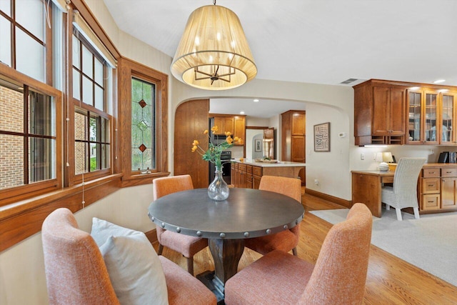 4765 N Woodburn St, Whitefish Bay, WI 53211 - dining area featuring arched walkways, light wood-style floors, and recessed lighting