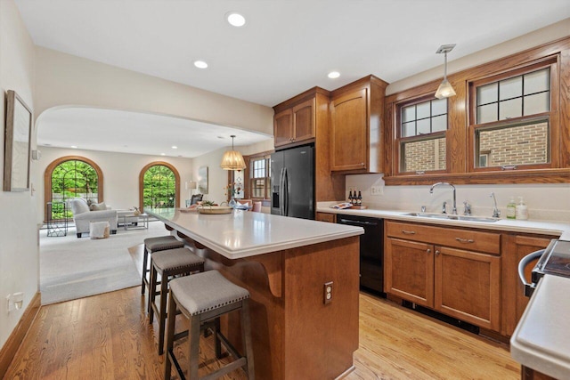 4765 N Woodburn St, Whitefish Bay, WI 53211 - kitchen with refrigerator with ice dispenser, dishwasher, open floor plan, brown cabinets, and light wood-style flooring