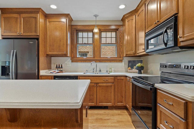 4765 N Woodburn St, Whitefish Bay, WI 53211 - kitchen featuring black appliances, light countertops, hanging light fixtures, brown cabinetry, and recessed lighting