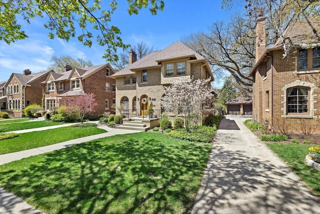 4765 N Woodburn St, Whitefish Bay, WI 53211 - view of front of property featuring a residential view, a front yard, brick siding, a chimney, and a detached garage