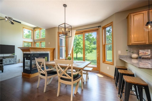 2193 County Road C, New Richmond, WI 54017 - dining area with healthy amount of natural light, a multi sided fireplace, dark wood-style floors, and a chandelier