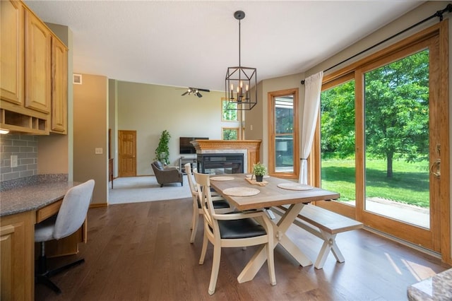 2193 County Road C, New Richmond, WI 54017 - dining space with a glass covered fireplace, dark wood-type flooring, a chandelier, and an office area