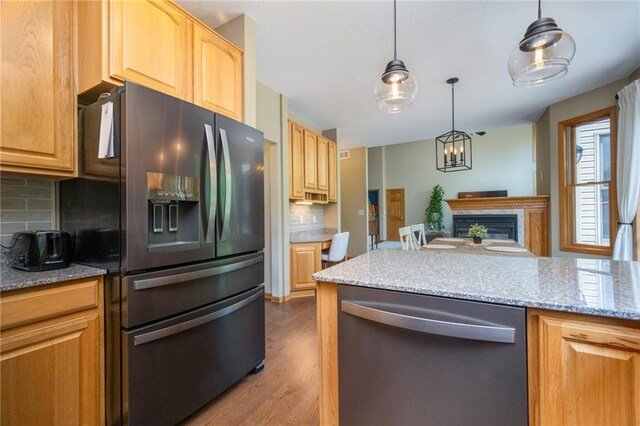 2193 County Road C, New Richmond, WI 54017 - kitchen with dishwasher, refrigerator with ice dispenser, tasteful backsplash, wood finished floors, and a fireplace