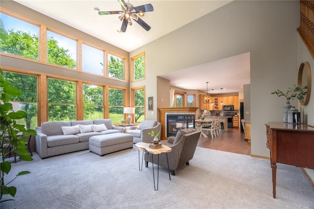 2193 County Road C, New Richmond, WI 54017 - living room with light carpet, a towering ceiling, ceiling fan, and a glass covered fireplace