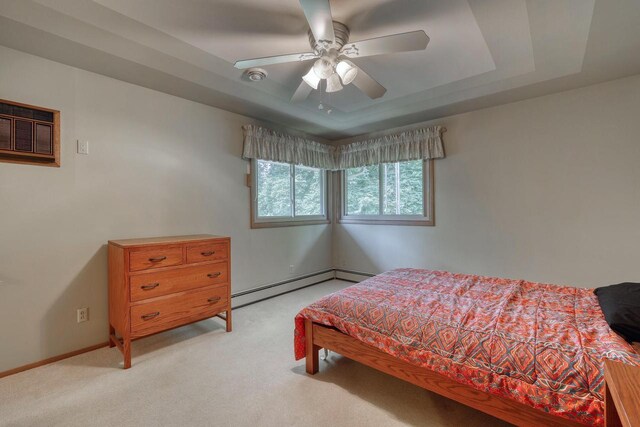 627 W Wisconsin St, Palmyra, WI 53156 - bedroom with a tray ceiling, light colored carpet, baseboard heating, a wall unit AC, and a ceiling fan