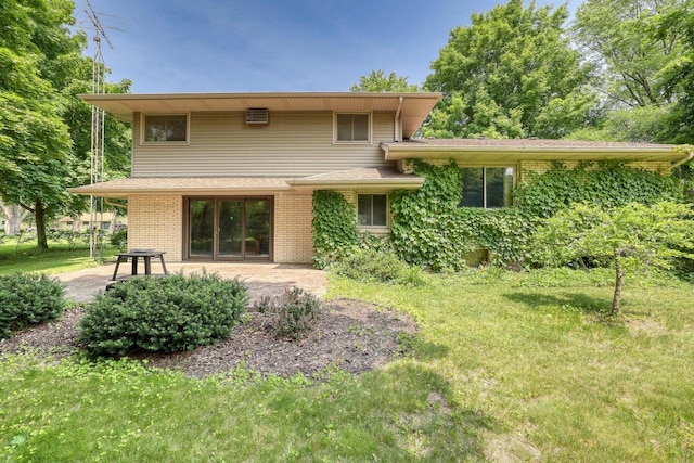627 W Wisconsin St, Palmyra, WI 53156 - back of house featuring a patio, brick siding, and a lawn