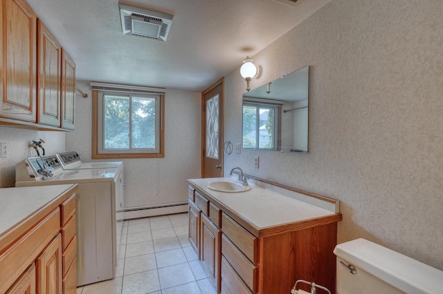 627 W Wisconsin St, Palmyra, WI 53156 - laundry room featuring washing machine and dryer, a baseboard heating unit, cabinet space, and light tile patterned floors