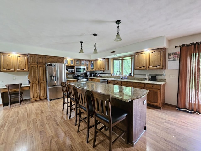 200890 Robin Rd, Marshfield, WI 54449 - kitchen with appliances with stainless steel finishes, a breakfast bar, light wood-style flooring, and glass insert cabinets