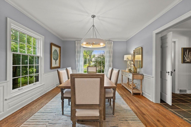6123 N Berkeley Blvd, Whitefish Bay, WI 53217 - dining area with a chandelier, wood finished floors, crown molding, a wainscoted wall, and a decorative wall