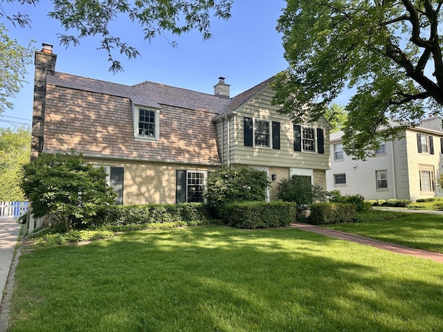 6123 N Berkeley Blvd, Whitefish Bay, WI 53217 - view of front of house with a chimney, a front yard, brick siding, and a high end roof