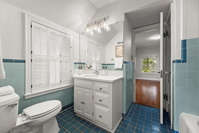 6123 N Berkeley Blvd, Whitefish Bay, WI 53217 - bathroom featuring tile walls, tile patterned flooring, vanity, vaulted ceiling, and a bathtub