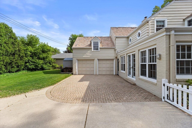 6123 N Berkeley Blvd, Whitefish Bay, WI 53217 - view of side of property with a lawn, decorative driveway, and a garage