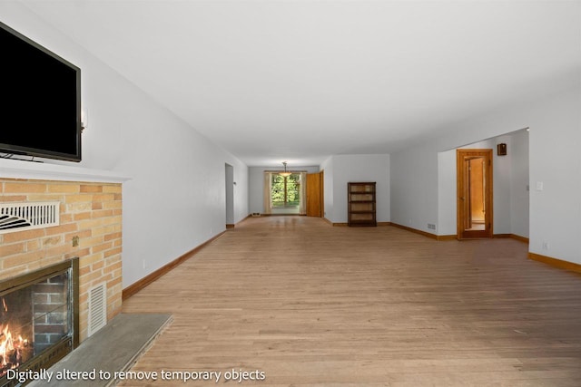 452 Woodland Dr, Wisconsin Rapids, WI 54494 - unfurnished living room featuring a brick fireplace and wood finished floors