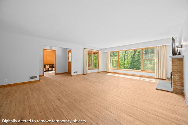 452 Woodland Dr, Wisconsin Rapids, WI 54494 - unfurnished living room featuring light wood finished floors and a brick fireplace