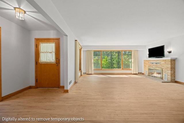 452 Woodland Dr, Wisconsin Rapids, WI 54494 - unfurnished living room featuring light wood finished floors and a fireplace