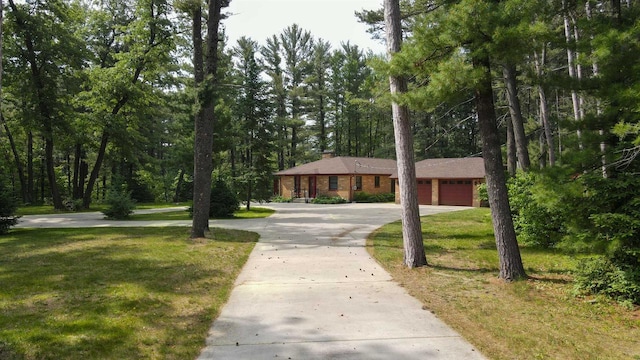 452 Woodland Dr, Wisconsin Rapids, WI 54494 - single story home featuring concrete driveway, a front lawn, an attached garage, and a chimney