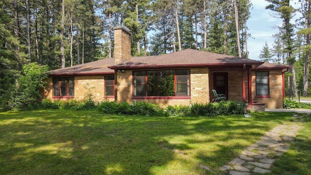 452 Woodland Dr, Wisconsin Rapids, WI 54494 - view of front of property with a front lawn, brick siding, a chimney, and roof with shingles