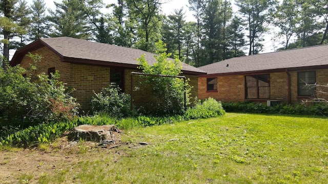 452 Woodland Dr, Wisconsin Rapids, WI 54494 - view of front of house with brick siding, a front yard, and roof with shingles